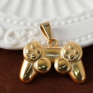 Detail view of a 24K gold-plated game controller pendant on a soft brown velvet surface