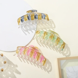 Nahaufnahme der Haarklammern aus Acryl mit Goldfolie und buntem Marmormuster für Damen