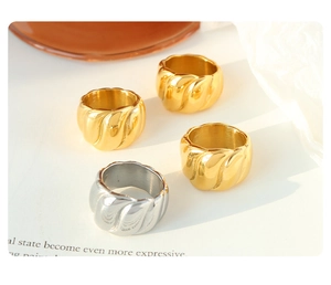 Nahaufnahme von klobigen Gold- und Silber-Croissant-Ringen mit gedrehter Textur auf Papier