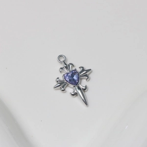 Macro view of silver cross pendant with fleur-de-lis design and purple heart zirconia