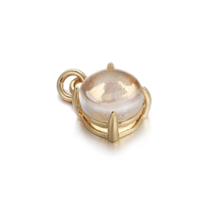 Close-up of a gold-plated heart-shaped pendant with a clear round gemstone inlay