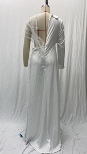 Détail de robe asymétrique blanche avec patchwork de dentelle et broderie de perles
