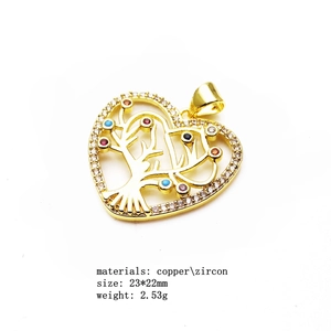 Detail of copper gold-plated heart pendant with zircon tree of life inlay design