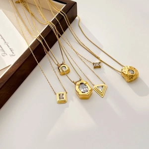 Golden geometric pendant necklaces with zircon crystals in square and triangle shapes