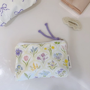 Macro detail of floral cotton coin purse with purple zipper pull and fabric label