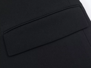 Close-up of black blazer dress flap pocket showing high-quality woven fabric texture