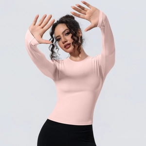 Détail du haut de yoga rose à manches longues avec taille ajustée et tissu respirant