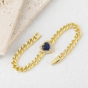 Gold-plated Cuban link bracelet featuring a deep blue heart gemstone and white zircon accents