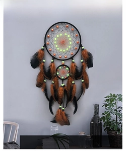 Glow-in-the-dark beads and black woven rings on dream catcher with brown feathers