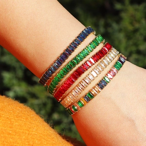 Detail showing stacked tennis bracelets with colorful zircon stones in gold finish