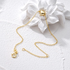 Detailed view of the 925 hallmark on a heart pendant gold necklace on a white petal