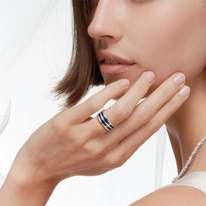 Primo piano di una modella con anello in acciaio al titanio nero e collana di diamanti