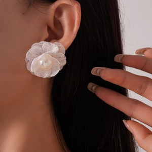 Detail of multi-layer lace flower earring with a pearl center on model's ear