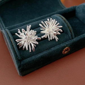 Macro shot of silver fireworks zircon stud earrings in a luxury velvet jewelry box