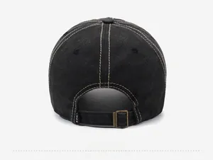 Close-up of adjustable metal buckle and XTM logo tag on black vintage baseball cap