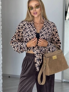 Elegante camicia a maniche lunghe con stampa geometrica, pantaloni scuri e borsa scamosciata