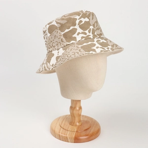 Detailansicht eines Fischerhutes mit Leoparden- und Kuhmuster auf einem Holz-Mannequin