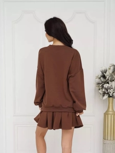 Vista posteriore di un set casual da donna con felpa marrone scuro e gonna a pieghe