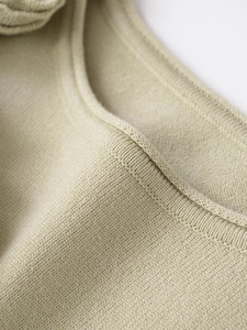 Vista macro della trama in maglia fine ad alta densità e dettagli delle cuciture verde chiaro