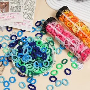 Macro shot of colorful high-elasticity hair ties stored in a clear jar and on display