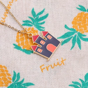 Collier château bleu Halloween avec toit rouge et chaîne dorée sur fond de tissu décoré