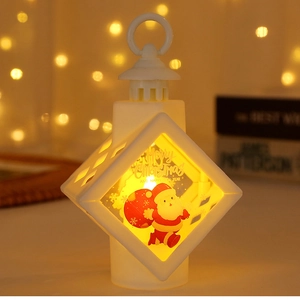 Close-up of a white LED Christmas lantern with Merry Christmas text and warm bokeh light