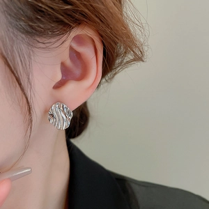 Macro side view of silver wave texture rhombic earring on model showing metallic luster
