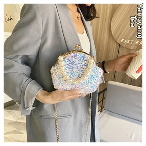 Iridescent sequin shell bag with large faux pearl handle and metal chain detail