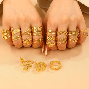 Detailed view of assorted gold stainless steel adjustable rings on silk fabric background