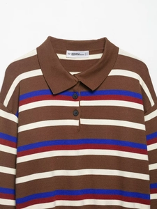Detail of multi-color striped knit polo shirt with buttoned collar and soft texture