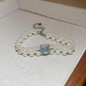Détail d'un bracelet de perles à double rangée avec pierre bleue carrée et cristaux micro-pavés