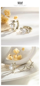 Detail of coffee gold huggie earrings featuring heart and pear shaped zircon stones