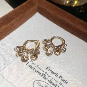 Macro shot of French vintage gold hoop earrings with champagne diamond tassel pendants