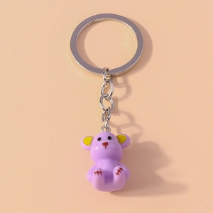 Close-up of purple resin bear keychain with yellow ears and silver metal ring and chain