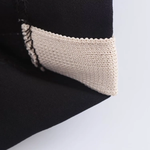 Macro detail of high-quality stitching between black woven and beige knit fabric cuff