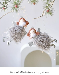 Detail showing plush Christmas angel ornaments with grey feathers and silver crowns