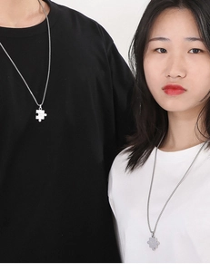Couples wearing stainless steel silver puzzle piece pendants on thin metal chains