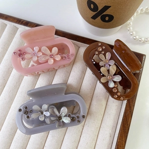Elegant floral acetate hair claws with rhinestones in pink, brown, and blue colors