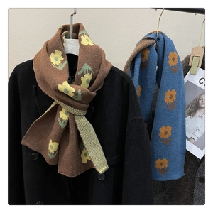Close-up of thick floral knitted scarves in brown and blue with soft texture detail