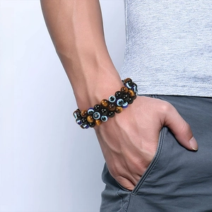 Mens 8mm tiger eye bead bracelet with evil eye charm shown on a models wrist