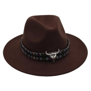 Detail of western fedora hat featuring ethnic woven band and silver bull head emblem