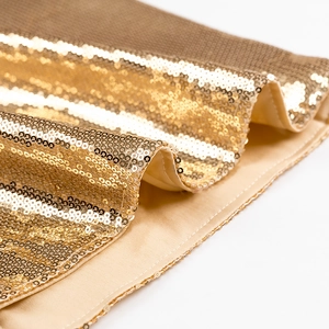 Detaillierte Nahaufnahme goldener Pailletten auf Netzfutter für ein elegantes Abendkleid