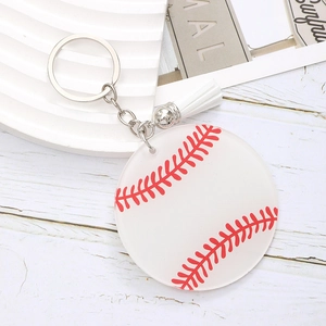 Baseball acrylic keychain with white tassel and silver ring on wooden surface