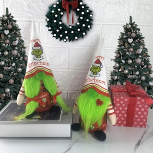 Close-up of Grinch themed Christmas gnomes with green beards and festive inscriptions