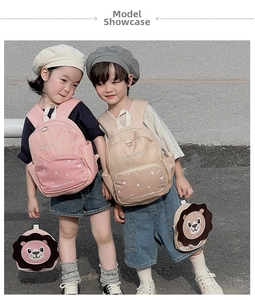 Detailed outdoor view of pink and beige kids backpacks with cute lion accessory and stars