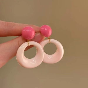 Macro detail of French vintage resin hoop earrings in shades of pink with gold metal accents