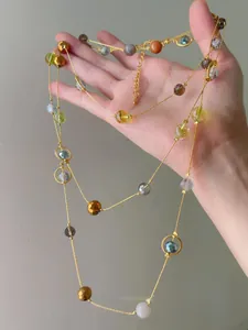 Detail of colorful multi-bead necklace with gold chain and faceted stones