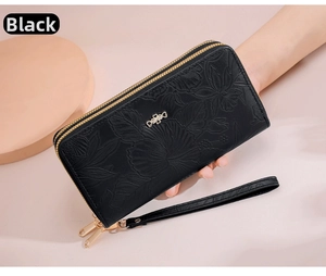 Detail of black leather wallet with floral embossing, double zipper, and bow accent