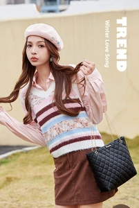 Sac bandoulière noir matelassé porté avec une tenue d'hiver et un béret rose chic