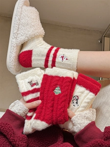 Detail of warm winter socks featuring festive snowman and penguin embroidery in red and white